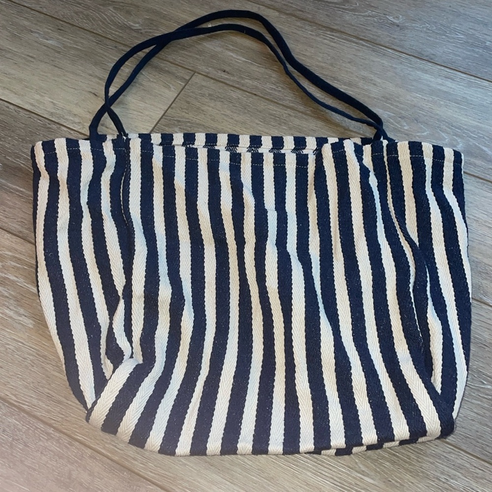 Canvas tote. Open with no closure or pockets. Great reusable shopping bag!